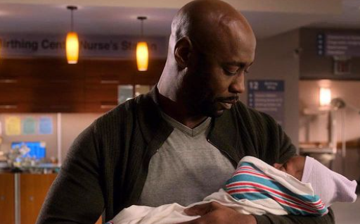 DB Woodside holding a baby in the Lucifer movie set.